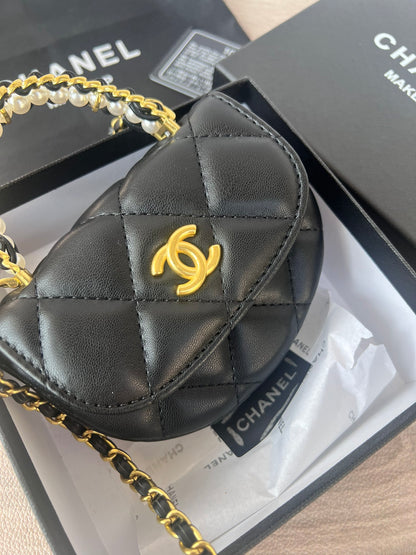 Close-up of gold hardware on black pearl chain mini bag