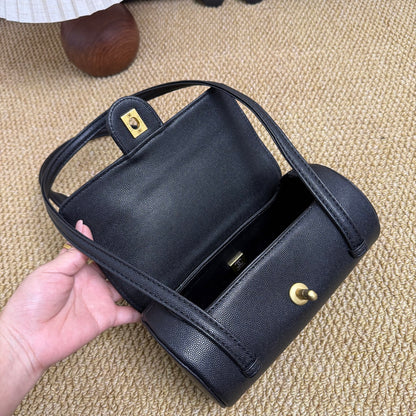 Elegant black mini barrel bag with structured cylindrical silhouette