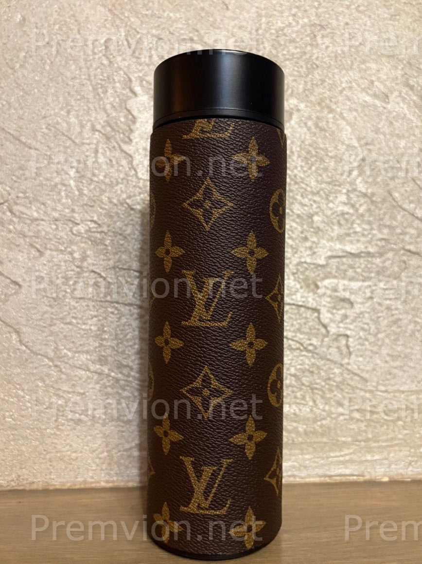 Luxury stainless steel vacuum mug wrapped in Louis Vuitton–style leather with LED temperature display lid on a wooden surface.