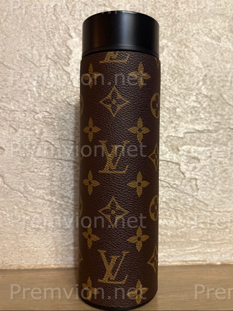 Luxury stainless steel vacuum mug wrapped in Louis Vuitton–style leather with LED temperature display lid on a wooden surface.