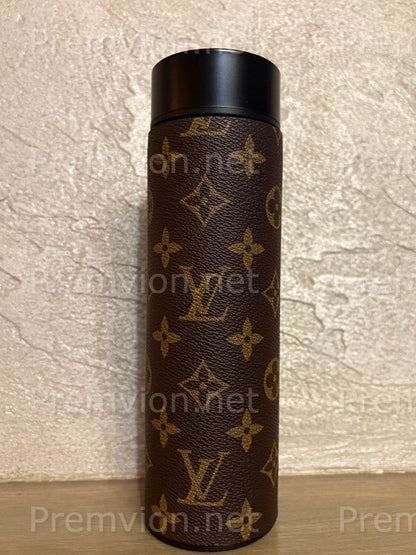 Luxury stainless steel vacuum mug wrapped in Louis Vuitton–style leather with LED temperature display lid on a wooden surface.