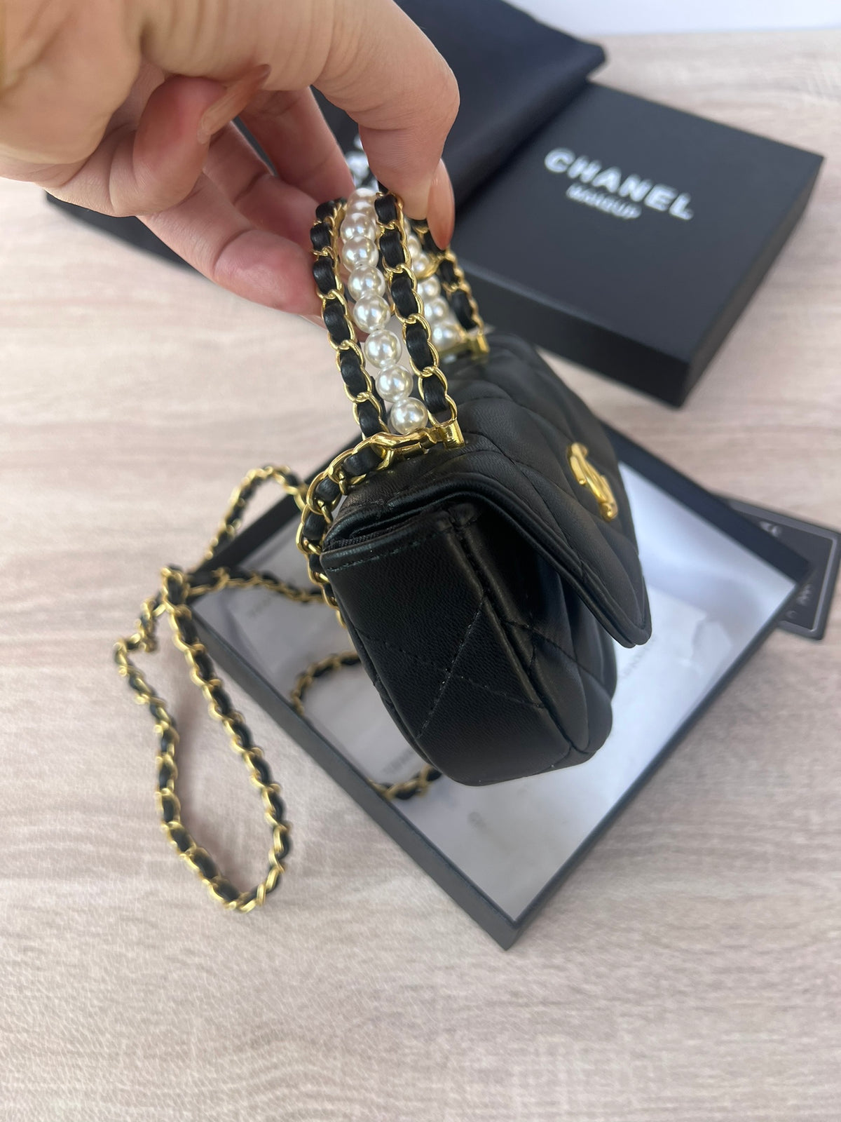 Luxury black pearl mini bag displayed with elegant gift box