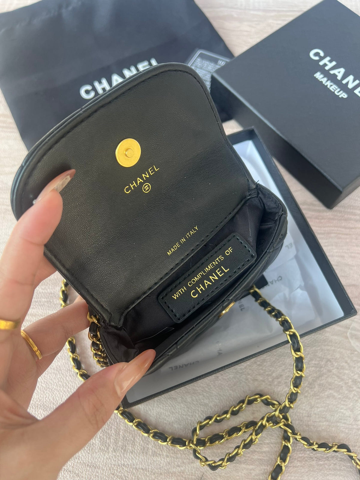Black mini shoulder bag with pearl and gold chain, styled view