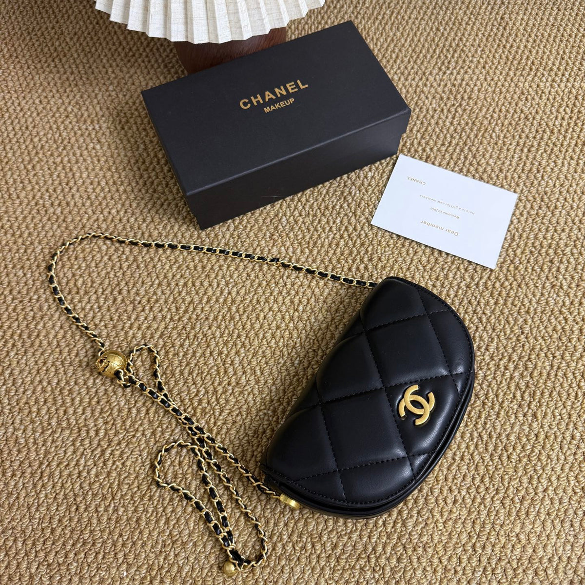 Black quilted mini crossbody bag with gold ball clasp, front view