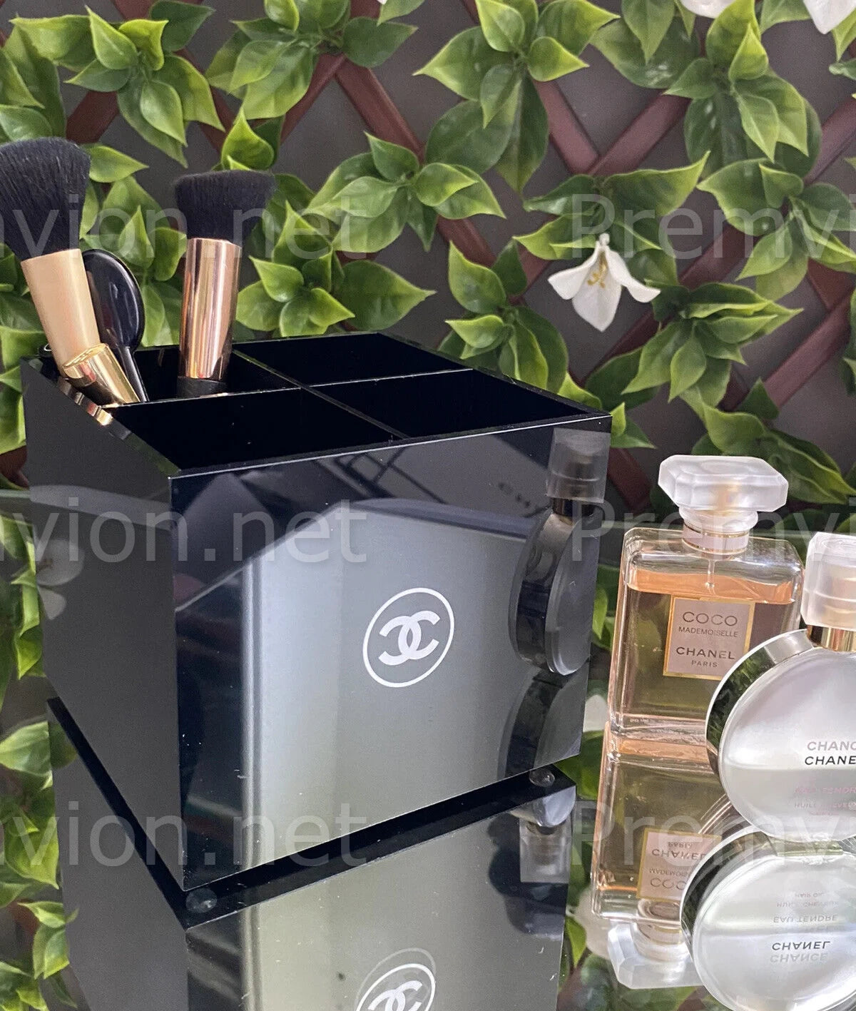 Chanel VIP gift black acrylic makeup brush holder with four compartments for luxury vanity organization.