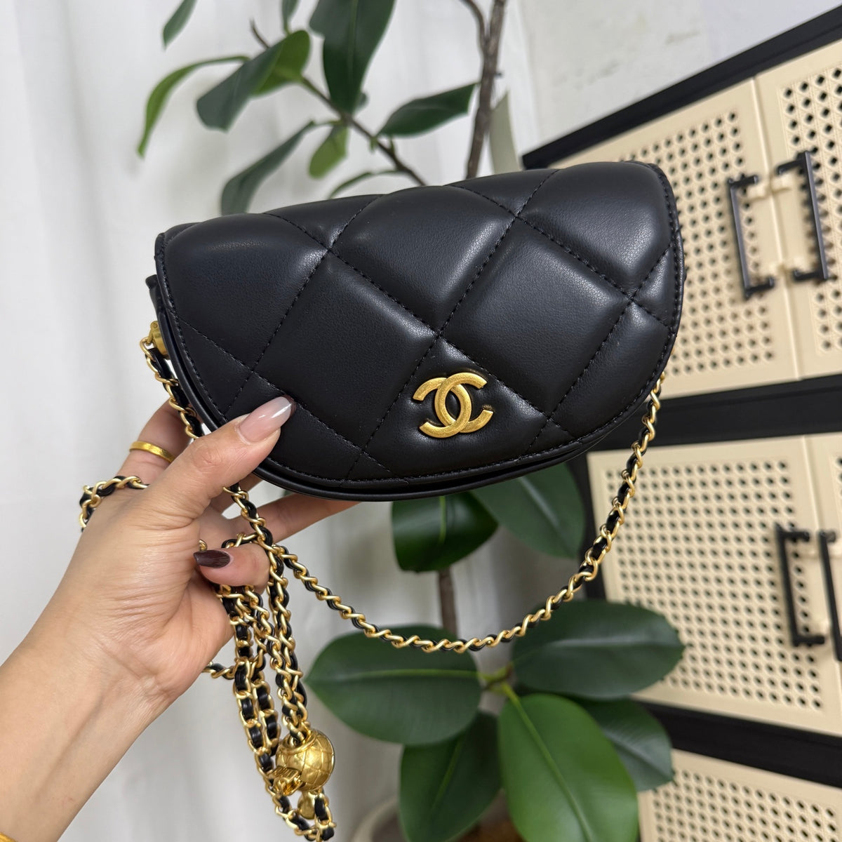 Black gold mini quilted bag with adjustable gold ball clasp, close-up