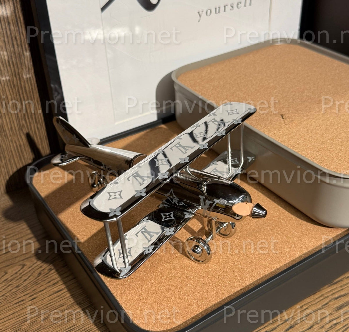 Silver Louis Vuitton Monogram aircraft collectible with sculpted wings and propeller