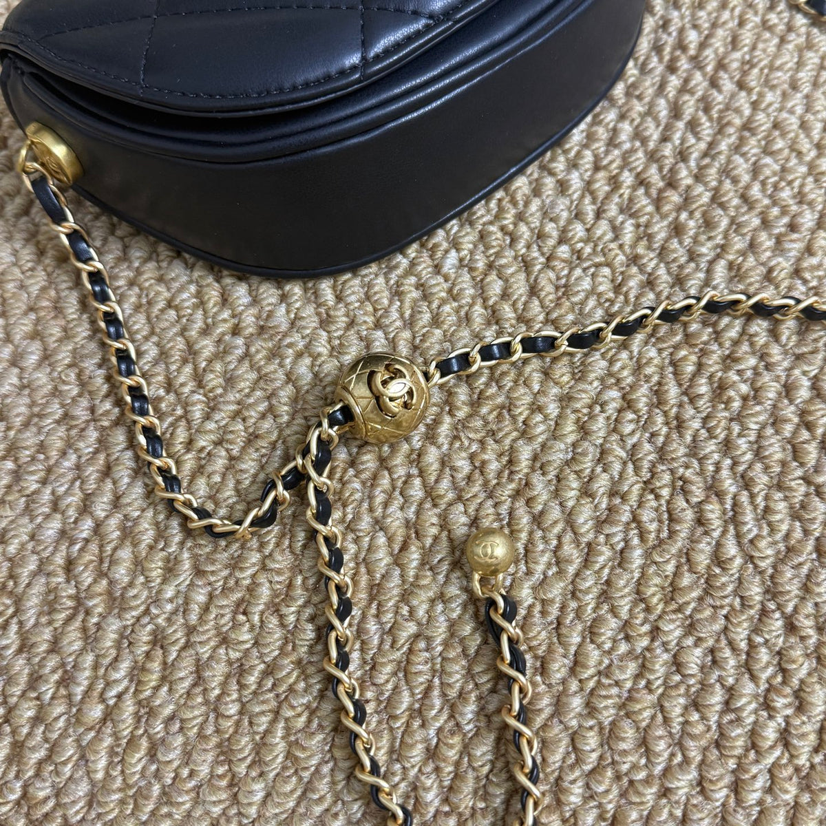 Luxury black quilted shoulder bag with gold ball clasp, full view