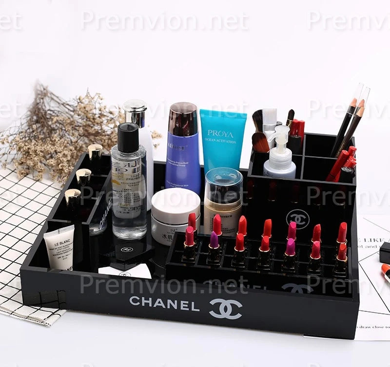 A black Chanel makeup organizer tray filled with cosmetics and skincare items