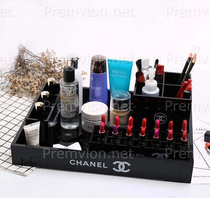 A black Chanel makeup organizer tray filled with cosmetics and skincare items
