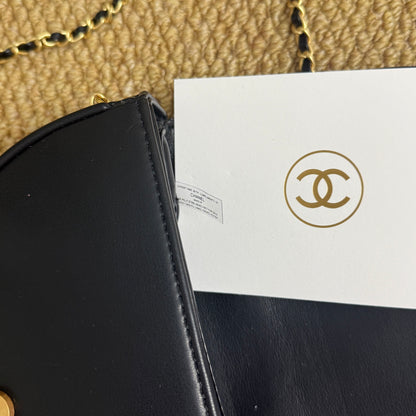 Luxury quilted mini handbag in black with gold hardware, angled view
