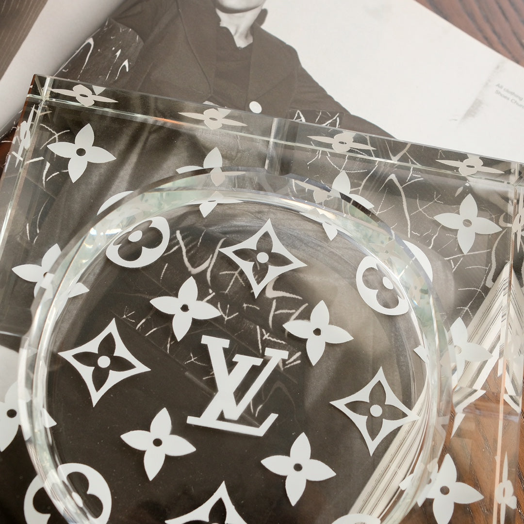 Close-up of etched monogram flowers on clear crystal glass ashtray surface
