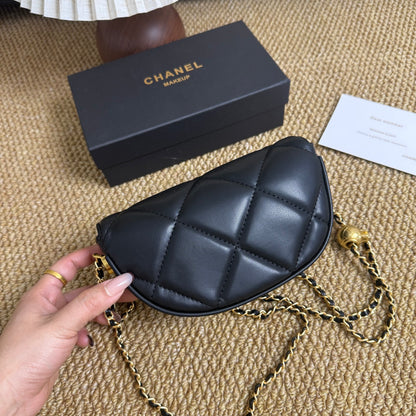 Mini quilted underarm shoulder bag in black with gold chain, styled view